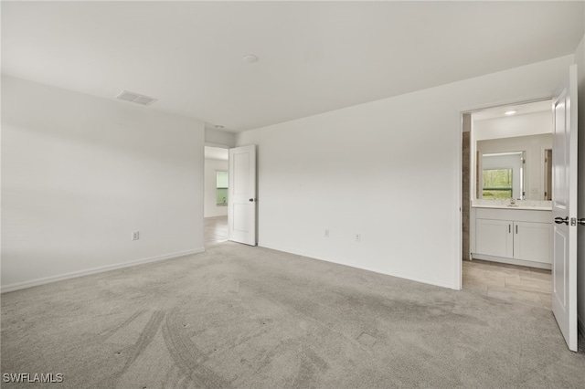 spare room with light carpet and sink