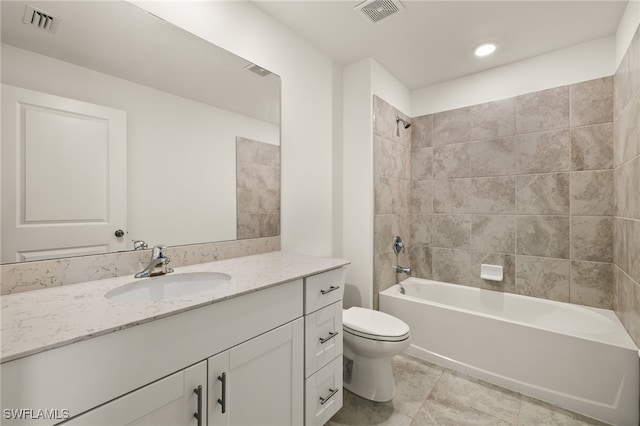 full bathroom featuring tile patterned floors, toilet, vanity, and tiled shower / bath