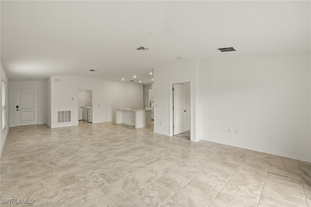 unfurnished living room featuring sink