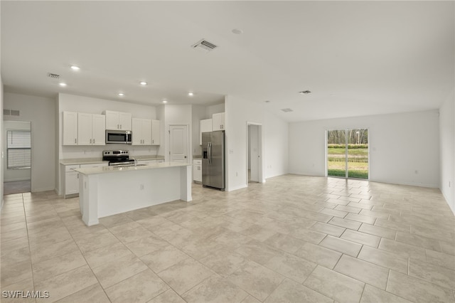 kitchen with white cabinets, an island with sink, and appliances with stainless steel finishes