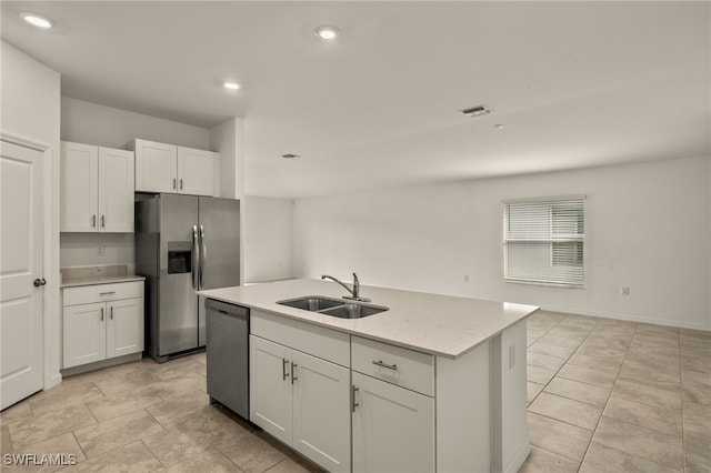 kitchen with sink, light stone counters, a center island with sink, white cabinets, and appliances with stainless steel finishes