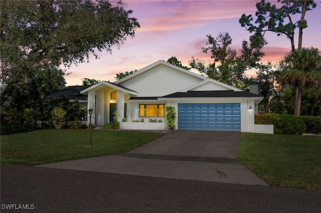 view of front of home with a lawn and a garage