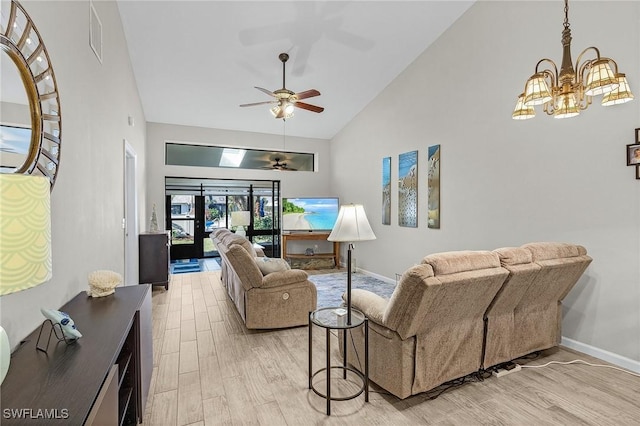 living room with ceiling fan with notable chandelier, high vaulted ceiling, and light hardwood / wood-style floors