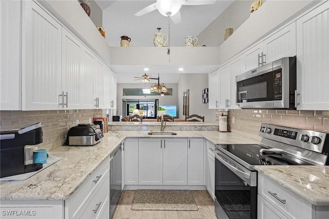 kitchen featuring ceiling fan, stainless steel appliances, a sink, and white cabinets