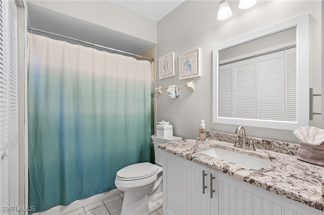 bathroom featuring vanity, tile patterned floors, and toilet