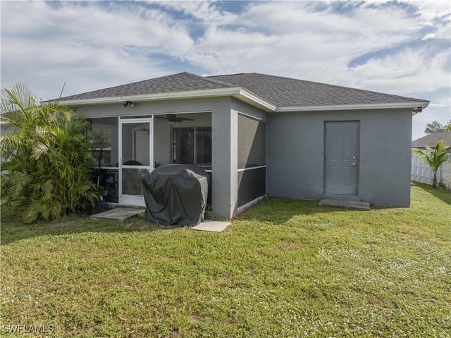 back of house featuring a yard and a sunroom