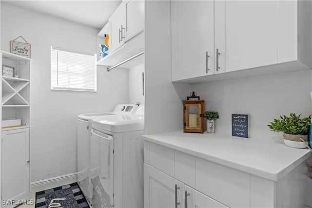 clothes washing area featuring cabinets and washing machine and clothes dryer