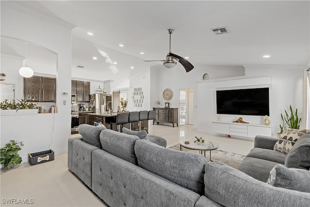 living room featuring ornamental molding, ceiling fan, sink, light tile patterned floors, and lofted ceiling