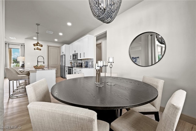 dining area with a chandelier and light hardwood / wood-style flooring