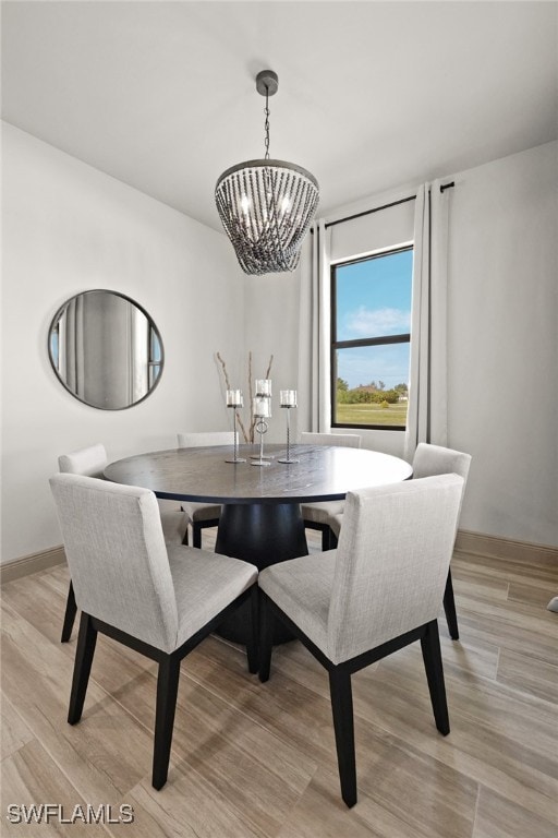 dining area featuring a notable chandelier and light wood-type flooring