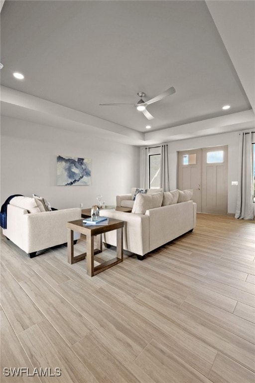 living room featuring light hardwood / wood-style flooring and ceiling fan