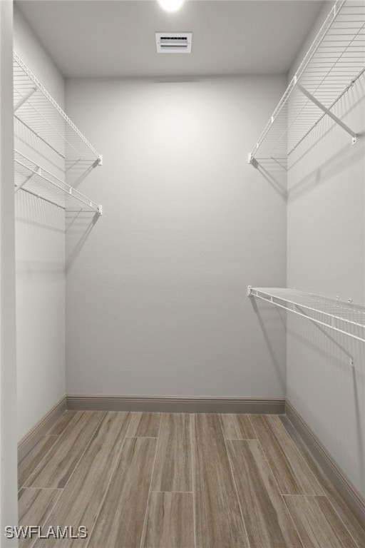 spacious closet featuring light hardwood / wood-style floors