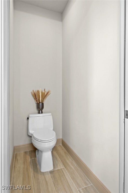 bathroom with hardwood / wood-style floors and toilet