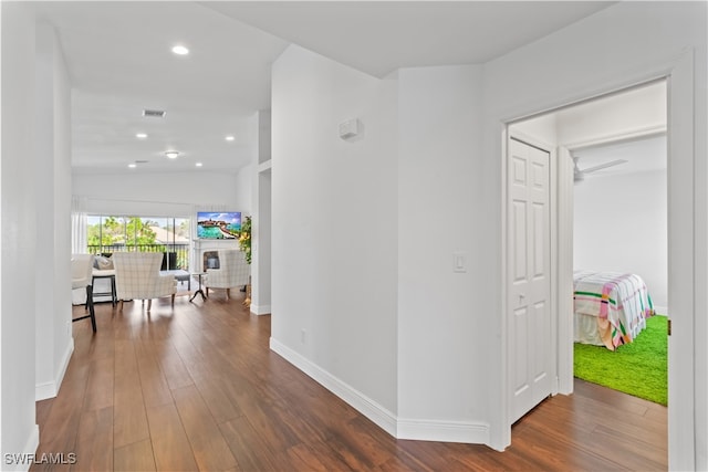 hallway featuring recessed lighting, visible vents, vaulted ceiling, wood finished floors, and baseboards