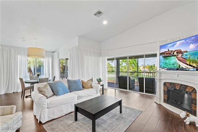 living room with a fireplace, visible vents, wood finished floors, and recessed lighting