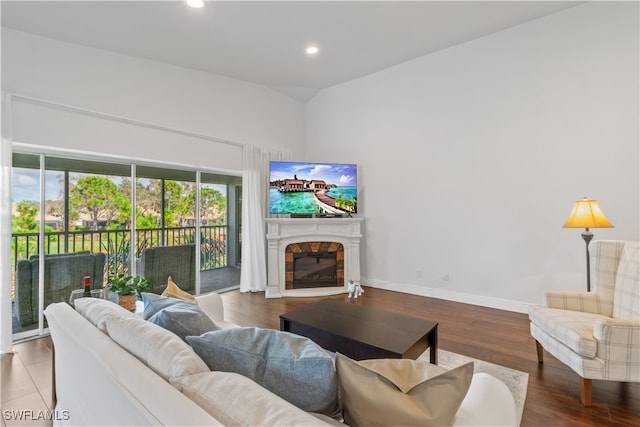 living room with wood finished floors, recessed lighting, a glass covered fireplace, and baseboards