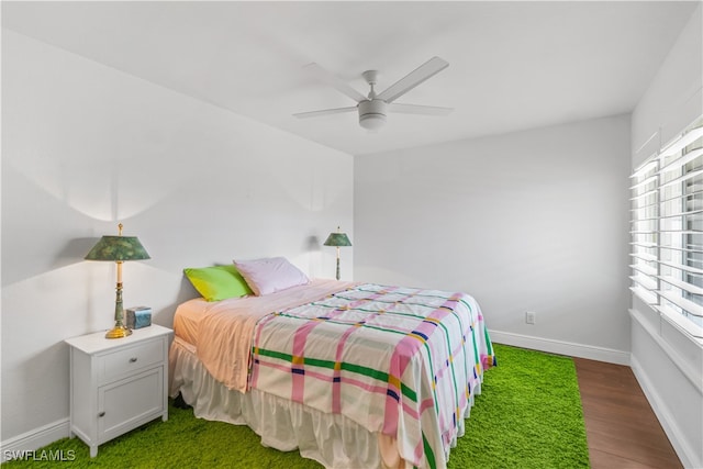 bedroom featuring ceiling fan, wood finished floors, and baseboards