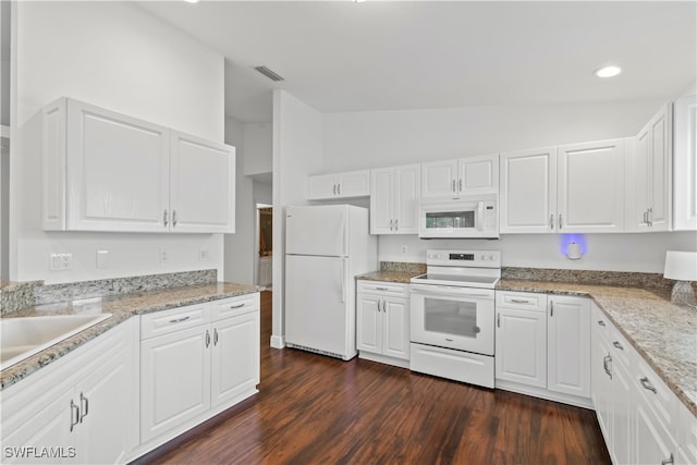 kitchen with white appliances, a sink, white cabinetry, vaulted ceiling, and dark wood finished floors