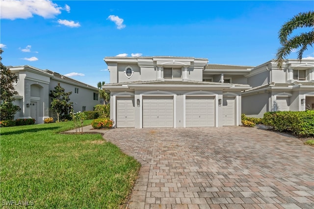 view of front of house with a front yard, decorative driveway, and stucco siding