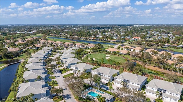 drone / aerial view with a residential view, a water view, and golf course view