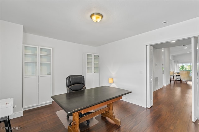 office area with dark wood-style floors, baseboards, and visible vents