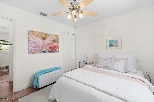 bedroom featuring wood-type flooring, a closet, and ceiling fan