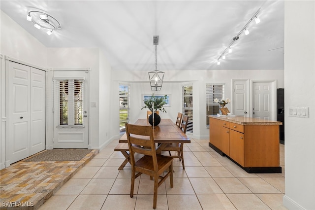 dining area with light tile patterned floors and track lighting