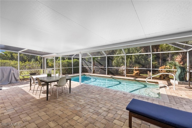 view of pool featuring glass enclosure and a patio