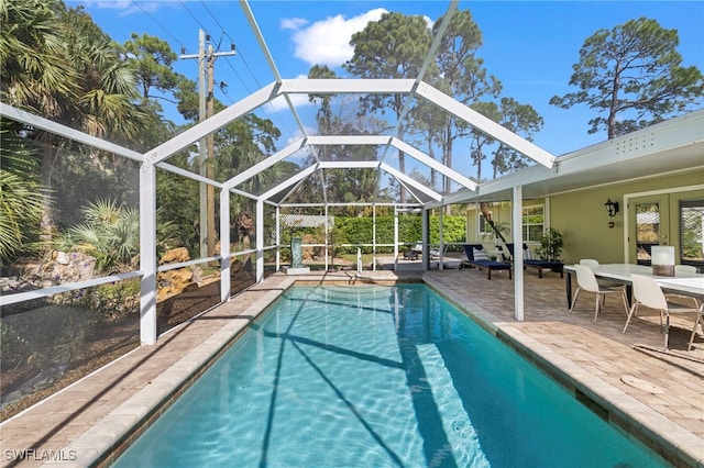 view of pool featuring glass enclosure and a patio area