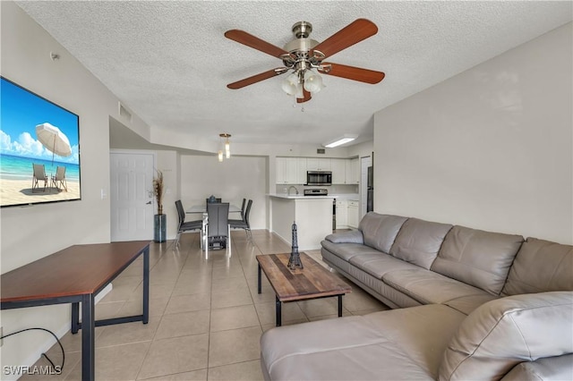 tiled living room featuring a textured ceiling and ceiling fan