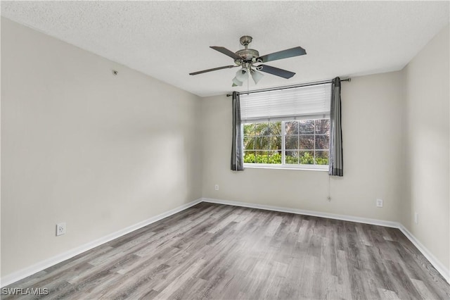 unfurnished room with ceiling fan, light wood-type flooring, and a textured ceiling