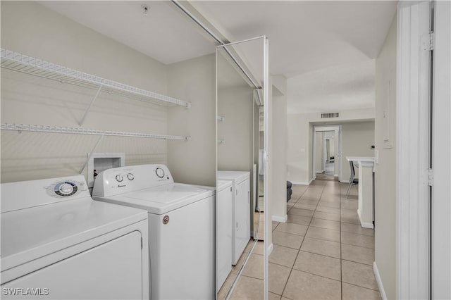 washroom with light tile patterned floors and washer and clothes dryer