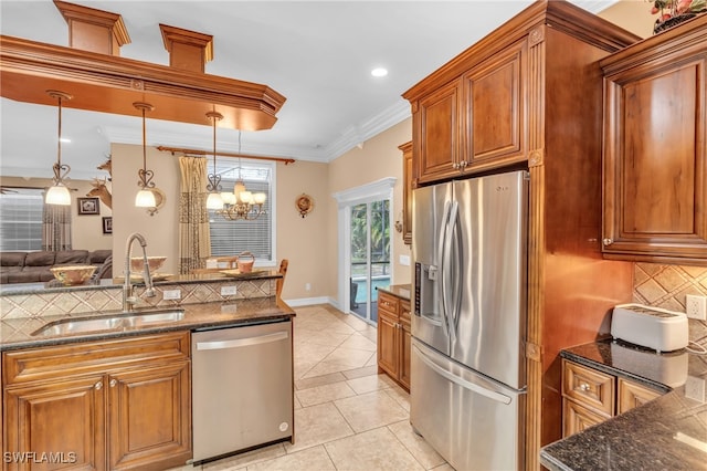 kitchen with backsplash, crown molding, sink, hanging light fixtures, and stainless steel appliances