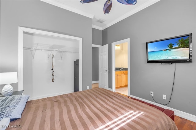 bedroom featuring connected bathroom, ceiling fan, crown molding, hardwood / wood-style floors, and a closet