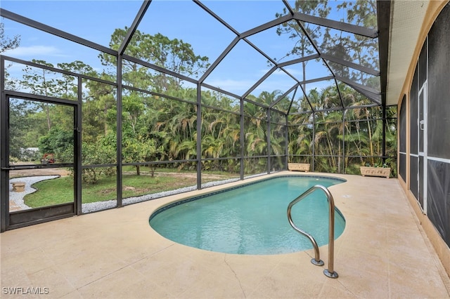 view of swimming pool featuring glass enclosure and a patio