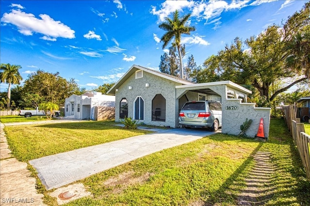 view of front of property with a front yard and a carport