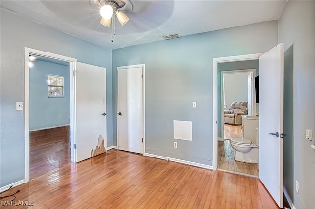 bedroom with ceiling fan, ensuite bathroom, and light hardwood / wood-style floors