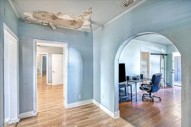 hallway featuring wood-type flooring and ornamental molding