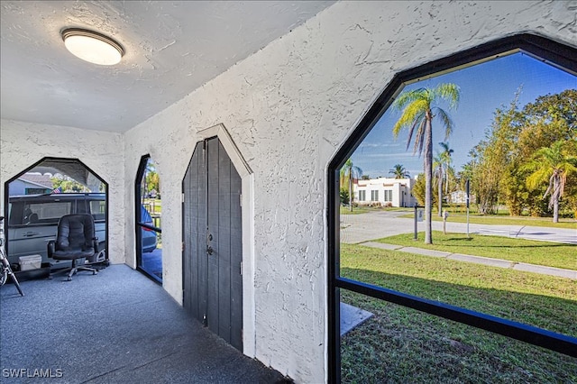 corridor with a textured ceiling and vaulted ceiling