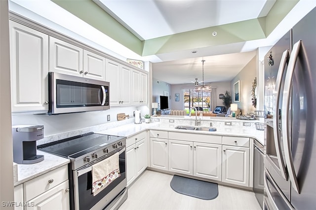 kitchen featuring appliances with stainless steel finishes, white cabinetry, ceiling fan, and sink