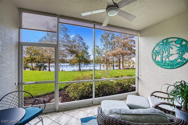 sunroom / solarium featuring ceiling fan and a water view