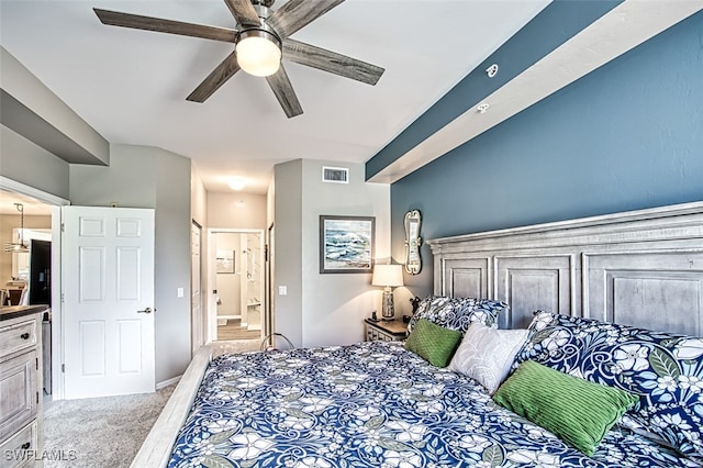 bedroom featuring light colored carpet, ensuite bath, and ceiling fan