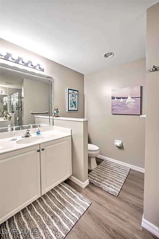 bathroom with hardwood / wood-style floors, vanity, and toilet