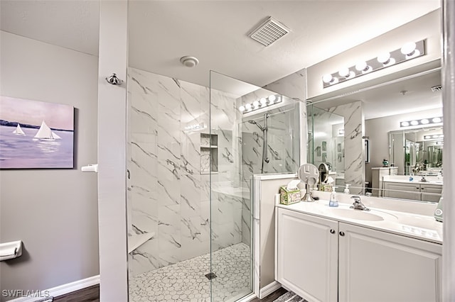 bathroom with vanity, wood-type flooring, and tiled shower