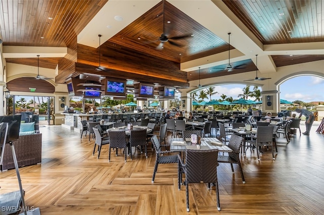 dining area with ceiling fan, beam ceiling, high vaulted ceiling, wooden ceiling, and light parquet flooring