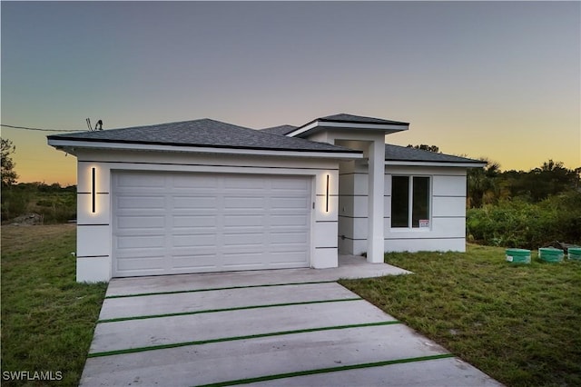 view of front of property with a yard and a garage