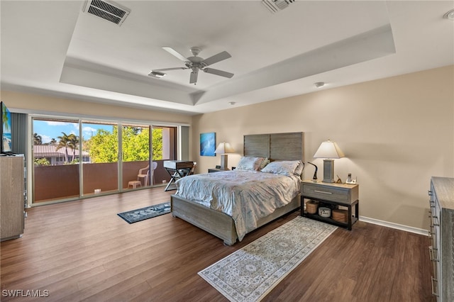 bedroom featuring hardwood / wood-style flooring, ceiling fan, a raised ceiling, and access to outside