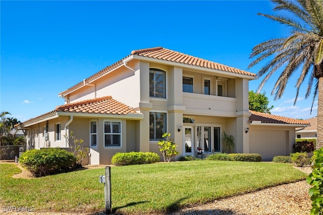 mediterranean / spanish home with a front yard and a garage