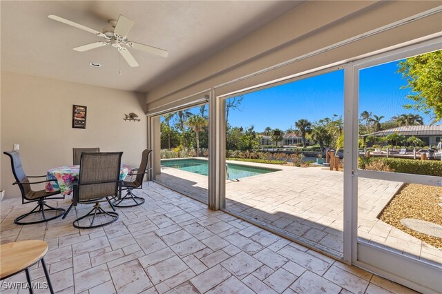 sunroom / solarium featuring ceiling fan and a swimming pool