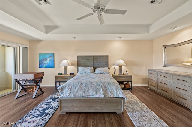 bedroom with a raised ceiling, ceiling fan, and dark hardwood / wood-style floors